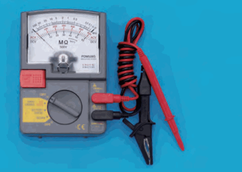 灰色の箱形の計器。目盛板に MΩ と 500V の字があり、下部に切替つまみ、赤い押しボタンがある。赤と黒のリード線とクリップが付いている