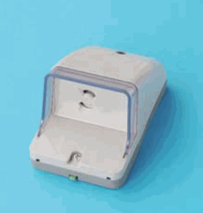 青い背景に置かれた灰白色の器具で,透明なふたの奥に差込口が1つあり(刃受が上下に2つ),下部にねじがあり,つまみはない