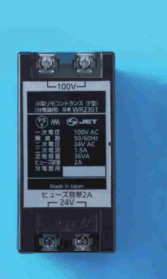 黒色の箱形の器具。上下にねじの端子があり,正面に 100V,小型リモコントランス(F型)(分電盤用) 品番 WR2301,PSEとJETのマーク,一次電圧 100V AC,周波数 50/60Hz,二次電圧 24V AC,二次電流 1.5A,定格容量 36VA,ヒューズ容量 2A,分電盤用,Made in Japan,ヒューズ容量2A,24V の字がある