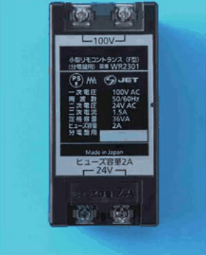 カラー写真。黒色の箱形の器具で,上下に端子のねじがあり,表示に 100V,小型リモコントランス,WR2301,100V AC,24V AC,ヒューズ容量2A,24V などの字がある