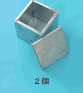カラー写真。銀色の金属製の深い四角い箱と，横に置かれた四角いふた。2個 の字
