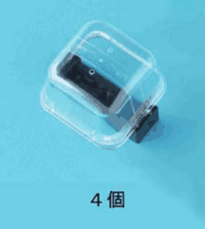 カラー写真。黒色の小さな部品に透明なふたが付いた物。4個 の字