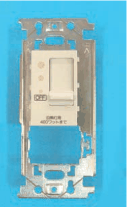 取付枠に付いたクリーム色の器具。縦長のつまみと3つの小さな丸い点,OFF の表示と 白熱灯用 400ワットまで の字がある