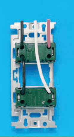 取付枠に緑色の器具が上下に2つ付いたものを裏から見た写真。各器具には左右に上下2つずつ電線の差込穴があり，下の器具の右側にWの字がある。上の器具の左上に黒，右上に赤の電線。上の器具の左下と下の器具の左上が黒の渡り線でつながる。白の電線は下の器具の右上に入る
