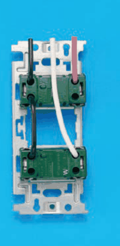 器具の裏面の写真。取付枠に上下2つの緑色の器具が付き，下の器具の右下にWの字がある。上から来た黒色の電線が上の器具の左の端子に入り，そこから黒色の渡り線が下の器具の左の端子へつながる。上から来た赤色の電線が上の器具の右の端子に入る（渡り線は無い）。上から来た白色の電線は上の器具を通らずに下の器具の右の端子に入る