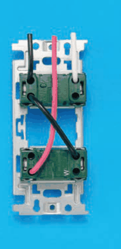 器具の裏面の写真。取付枠に上下2つの緑色の器具が付き，下の器具の右下にWの字がある。上から来た黒色の電線が上の器具の左の端子に入り，そこから黒色の渡り線が斜めに下の器具の右の端子へつながる。上から来た白色の電線が上の器具の右の端子に入る。上から来た赤色の電線は上の器具を通らずに下の器具の左の端子に入る