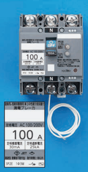灰色の器具で上下に3つずつ端子があり,上下の中央の端子にNの表示,上に電源側,下に負荷側の字,緑色のOFFのハンドルと丸いボタンがあり,下から白い電線1本が出ている。拡大した表示に 過負荷・短絡保護兼用 単3中性線欠相保護付 漏電ブレーカ,定格電圧 AC 100/200V,100 A,定格感度電流 30mA,定格遮断電流 25kA,3P2E 1Φ3W の字がある